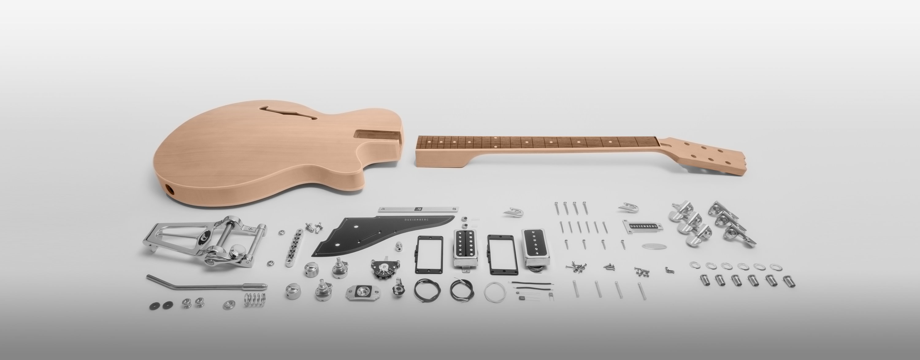 All parts of a Duesenberg Starplayer TV Electric guitar laid out on a grey background